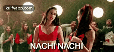 Two Women Are Standing Next To Each Other In Front Of A Crowd And The Words Nachi Nachi Are Written On The Screen . GIF