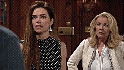 Two Women Are Standing Next To Each Other In Front Of A Door GIF