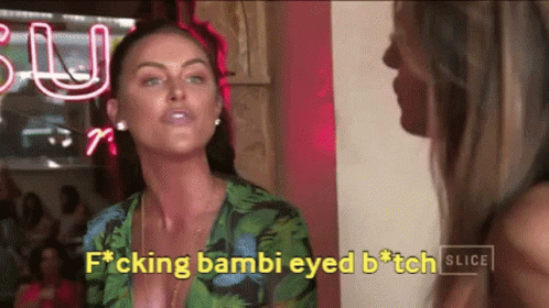 Two Women Are Standing Next To Each Other In Front Of A Neon Sign That Says Slice GIF