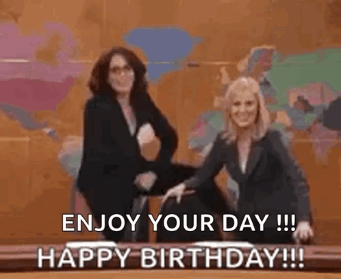 Two Women Are Standing Next To Each Other In Front Of A Table With The Words `` Enjoy Your Day ! '' GIF