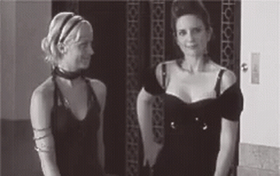 Two Women Are Standing Next To Each Other In Front Of An Elevator . GIF