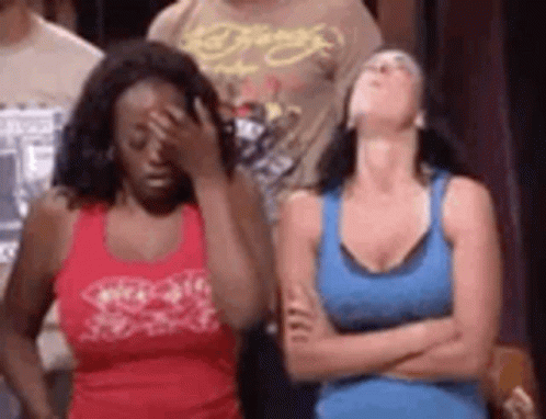Two Women Are Standing Next To Each Other With Their Arms Crossed And One Woman Is Covering Her Face . GIF
