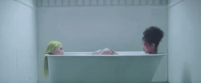 Two Women Are Taking A Bath In A Bathtub . GIF