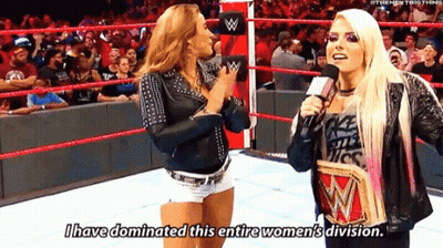 Two Women Are Talking In A Wrestling Ring And One Of Them Is Holding A Wrestling Championship . GIF