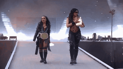 Two Women Are Walking Down A Ramp With A W Logo On The Bottom GIF