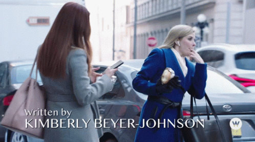Two Women Are Walking Down A Street With The Words Written By Kimberly Beyer Johnson On The Bottom GIF