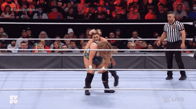 Two Women Are Wrestling In A Ring While A Referee Watches . GIF
