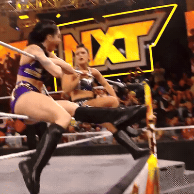 Two Women Are Wrestling In A Ring With The Word Nxt Behind Them GIF