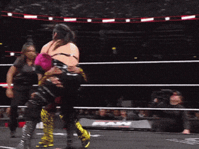 Two Women Are Wrestling In A Ring With The Word Raw On The Side GIF