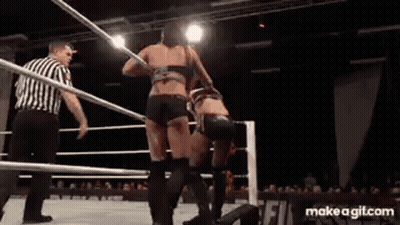 Two Women Are Wrestling In A Wrestling Ring With A Referee Watching . GIF