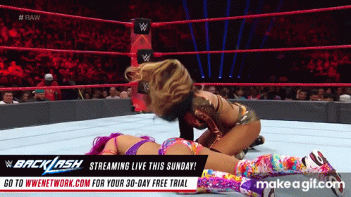 Two Women Are Wrestling In A Wrestling Ring With An Advertisement For Backlash GIF