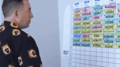 Two Women At Podiums With Economics Chalkboard GIF