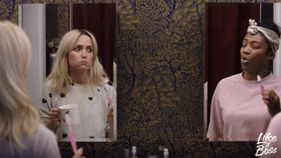 Two Women Brushing Their Teeth In Front Of A Mirror With Like A Boss Written On The Bottom GIF