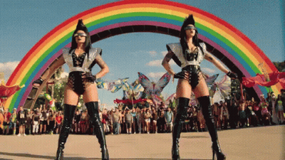 Two Women Dancing In Front Of Rainbow GIF