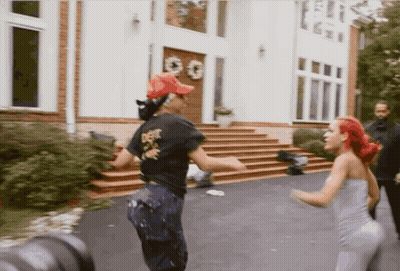 Two Women Dancing In Front Of White House With GG Sign GIF