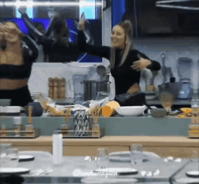 Two Women Dancing In Kitchen In Front Of Mirror GIF