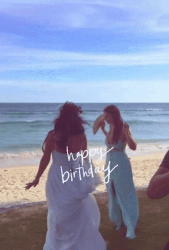 Two Women Dancing On A Beach With The Words Happy Birthday Written On The Beach GIF