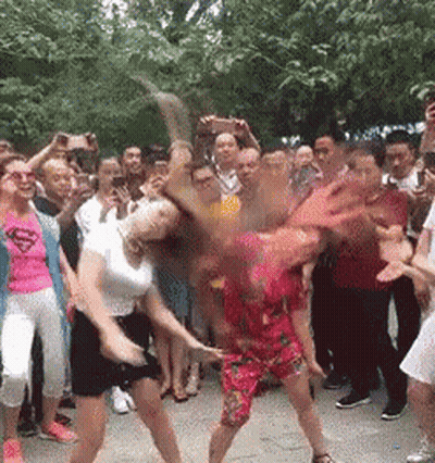 Two Women Dancing, One In Superman Shirt GIF