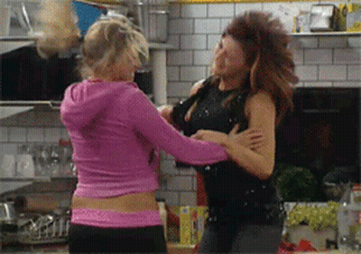 Two Women Fighting In Kitchen, One In Pink Hoodie GIF