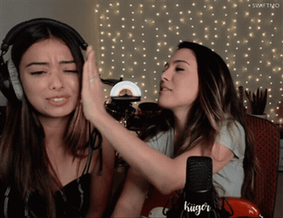 Two Women High Fiving In Front Of Kuger Microphone GIF
