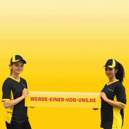 Two Women Holding A Yellow Banner That Says Wende-Einer-Von-Und GIF