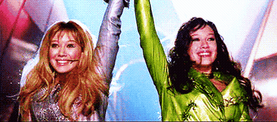 Two Women Holding Arms in the Air