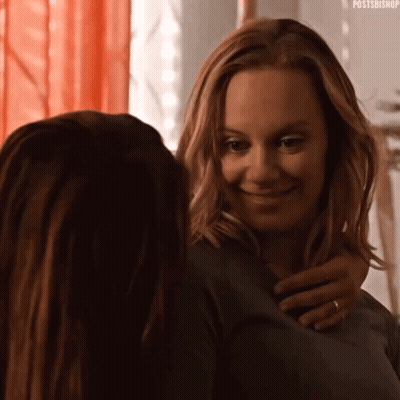 Two Women Hugging And Smiling In Mirror GIF