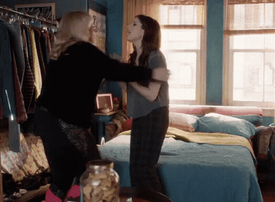 Two Women Hugging In A Bedroom With A Jar Of Cookies In The Foreground GIF