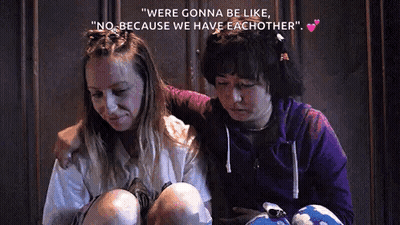 Two Women Hugging In Dark Room GIF