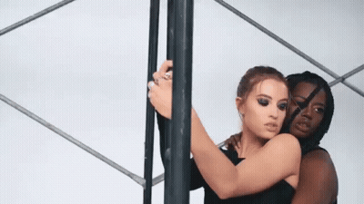 Two Women Hugging Next To Pole GIF
