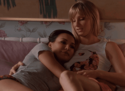Two Women Hugging On Bed One With Flower Shirt GIF