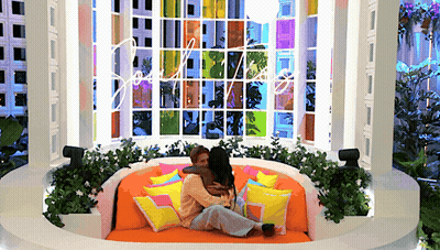 Two Women Hugging On Couch By Stained Glass Window GIF