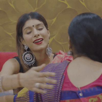 Two Women Hugging On Couch One Wearing Earrings GIF