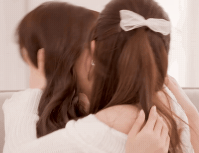 Two Women Hugging One With White Bow GIF
