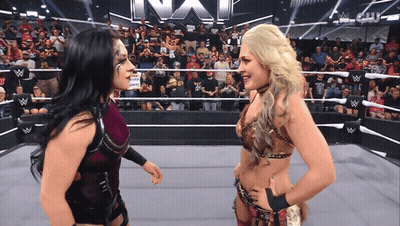 Two Women In A Wrestling Ring With The Word Nxt On The Wall GIF