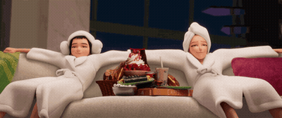 Two Women In Bathrobes Sitting On Couch With Snacks GIF