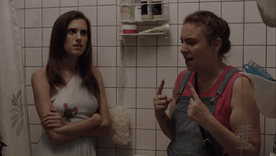 Two Women In Bathroom One Holding Shampoo GIF