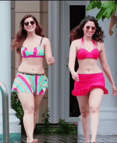 Two Women In Bikinis Are Walking In Front Of A House GIF