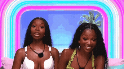 Two Women In Bikinis Smiling On Bed GIF