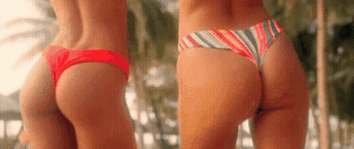 Two Women In Bikinis Standing By Palm Trees GIF