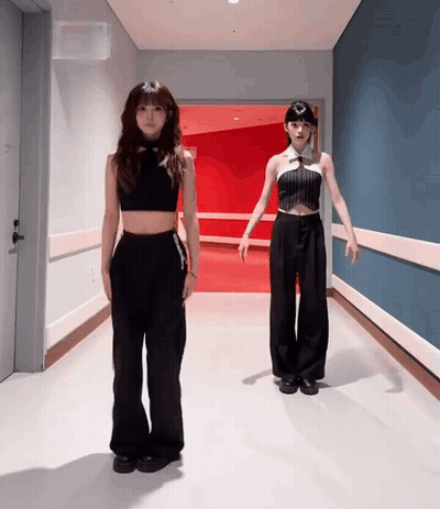 Two Women In Black In Hallway GIF