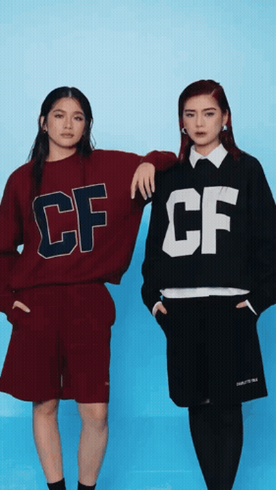 Two Women In CF Sweatshirts Standing Together GIF