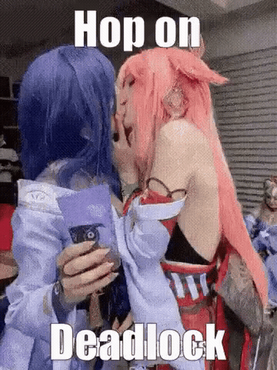 Two Women In Cosplay Hugging And Holding Cell Phone GIF
