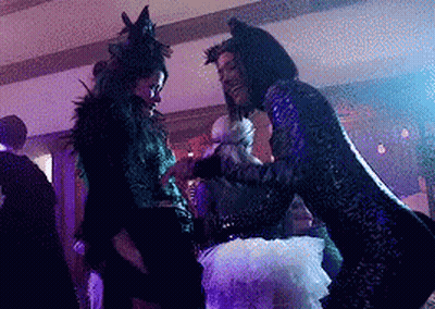Two Women In Costumes Dancing In Dark Room GIF