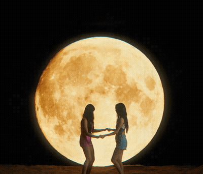 Two Women In Front Of Full Moon GIF