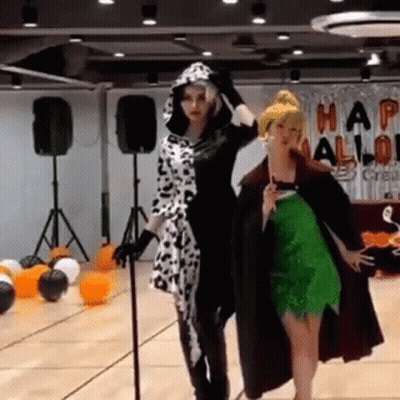 Two Women In Halloween Costumes With Balloons GIF