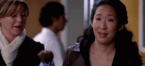 Two Women In Hallway One Holding Teddy Bear GIF