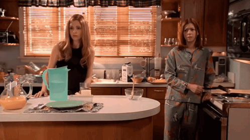 Two Women In Kitchen With Pitcher And Plate GIF