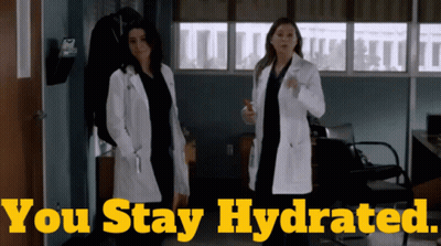 Two Women In Lab Coats Standing Next To Each Other With The Words " You Stay Hydrated " Behind Them GIF