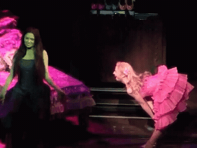 Two Women In Pink And Green Dresses On Stage GIF